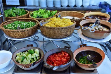 Malzemeler üzerinde bardak yayılmıştır. Geleneksel Vietnam çorba için doldurma: yeşil, kırmızı biber, yumurta noodle, et, kireç. Maşa ve kaşık doğru ürün alın. Kendinizi hazırlayın