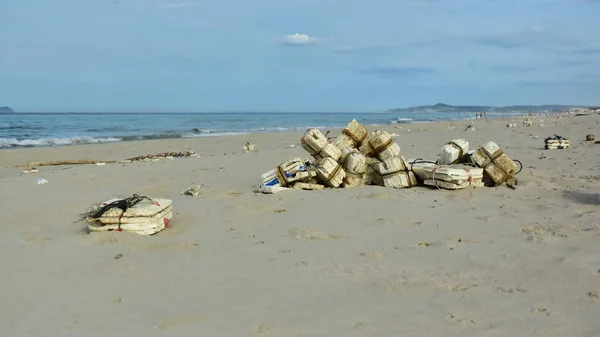 Self-made white  buoy a tied to a rope confused network fishing fish on a wet sand background ocean design beach fishing village. Garbage thrown ashore by waves