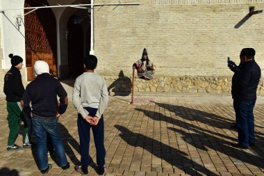 12 Şubat 2018. Buhara. Özbekistan. Eğlence için turist: yaşam heykel - sokak MIME sanatçı levitating
