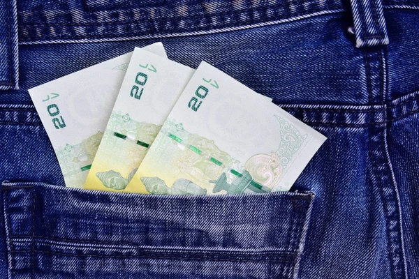 Thai money in the back pocket of jeans. Concept on a trip to Thailand