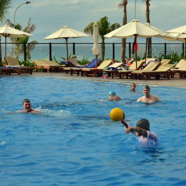 Cam Ranh, Vietnam. 13 Temmuz 2018.: bir grup insan bir su topu top havuzunda oynamayı. Sporcular içinde mavi ve siyah şapka, sarı top. Bu insanlar turist tatile dinlenmek için geldi.