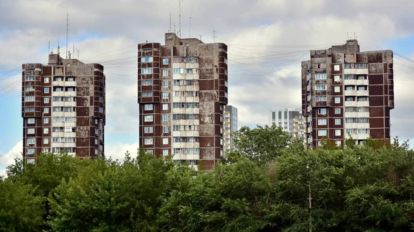 Üç tipik eski püskü yüksek ev park ağaçların arkasında