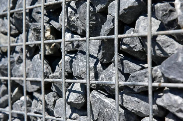 Wire Gabion Rock Fence. Metal Cage filled with rocks. Texture background of rock fence with cage.