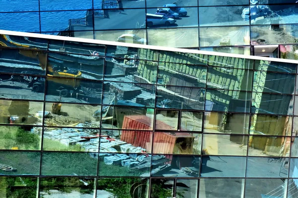 物質の容器と特別な装置を高層ビル建築現場のガラスの壁に反射 現代の都市建設をテーマに抽象的な背景 — ストック写真