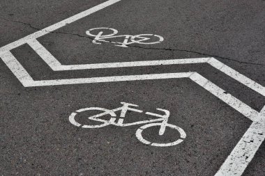 Bisiklet simgesi üzerinde asfalt beyaz boya ile boyanmıştır. Sinyal de yol bisiklet yönünü gösteren park işaretleme