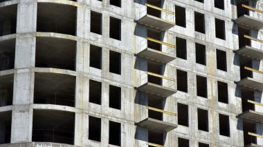 İnşaat halindeki binanın beton cephesi. Balkonlar ve camsız pencereler. Sivil inşaat konusunda arka plan ya da duvar kağıdı