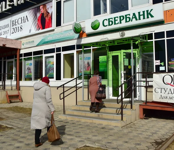 6 Nisan 2018. Krasnosyark. Rusya. İki yaşlı kadın banka Sberbank ofisine gidin. Onlar sıcak giyinmiş, havanın soğuk olduğu