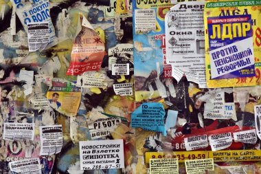 Krasnoyarsk. Rusya. 3 Ağustos 2018: bülten panosu yaşıyorum. Paramparça bir eski sarı duvar çeşitli reklam