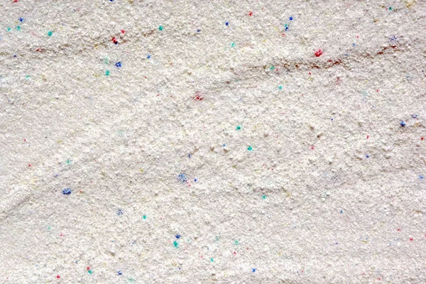 有色颗粒白色洗涤粉的固体背景 — 图库照片