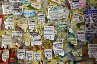 Krasnoyarsk. Rusya. 3 Ağustos 2018: bülten panosu yaşıyorum. Paramparça bir eski sarı duvar çeşitli reklam