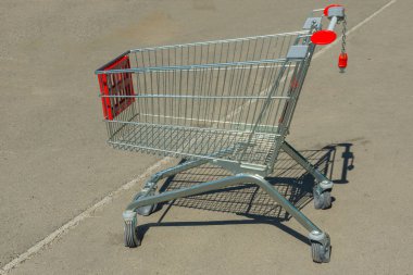 Asfalt kaplama üzerinde boş alışveriş sepeti. cart kırmızı plastik parçalar