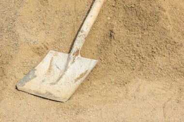 Çimento ve beton yalanlar üzerine kum yığını ile lekeli spade. Kopya alanı ile yakından görmek. Şantiyede iş kavramı