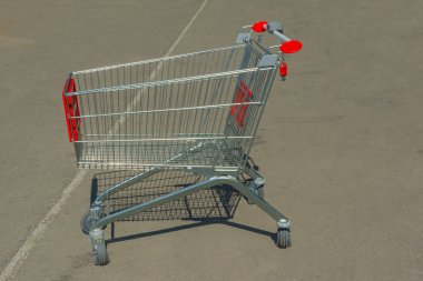 Asfalt kaplama üzerinde boş alışveriş sepeti. cart kırmızı plastik parçalar
