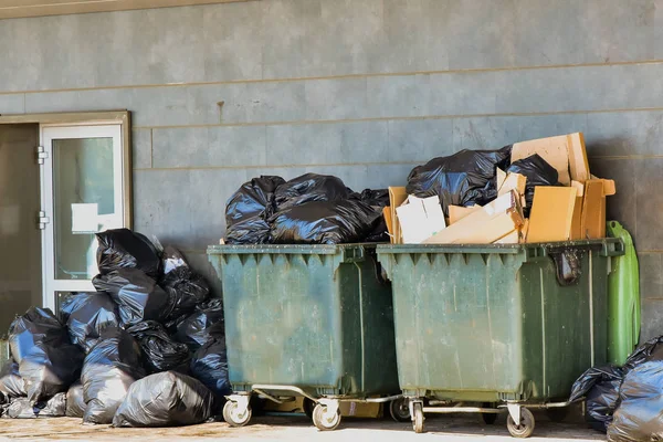垃圾容器用黑色塑料袋溢出 垃圾和纸板箱 — 图库照片