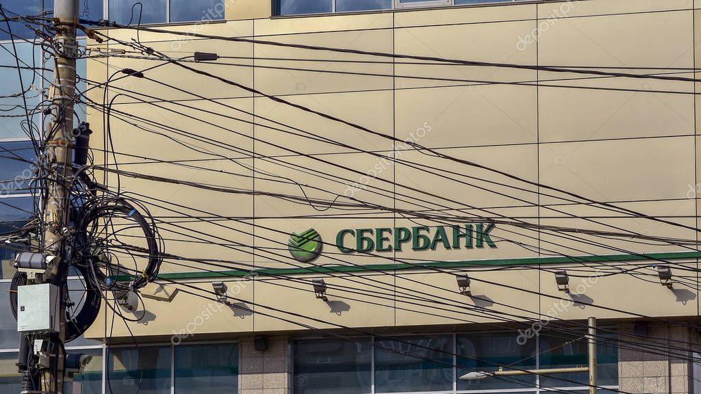 March 23, 2018. Krasnoyarsk. Russia. Wires on pole on background of facade with Sberbank logo