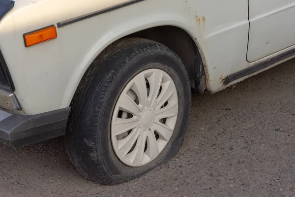 Flat rear tire on old rusty car