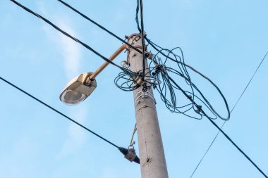 Bir lamba ve Fener elektrik telleri ile elektrik direği. Mavi bulutlu gökyüzü