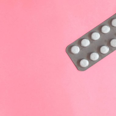 Blister pembe bir arka plan üzerinde beyaz hap. Metin için yer kopyalayın