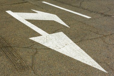 Asfalt yol üzerinde beyaz ok işaretleri