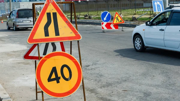 Work in progress. Roadworks, road signs. Men at work. Some signs signage for work in progress on urban street. left arrow. speed limit sign