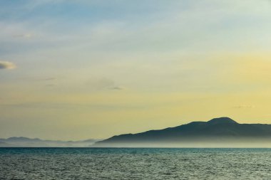 deniz ve mavi-sarı gökyüzü güzel hat. dev dağlarla siste