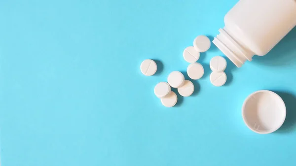 Pastillas Blancas Esparcidas Sobre Fondo Azul Pastillas Derramadas Del Frasco — Foto de Stock