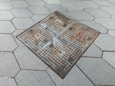 Kaldırım yollar arasında paslı kare şeklindeki kuyu