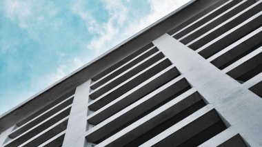 güzel bir mavi bulutlu gökyüzüne karşı büyük kirişler ve sütunlar ile modern yüksek katlı çok katlı beton bina. kare kentsel arka plan