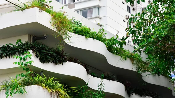 modern ecological building with lots of plants on the balcony