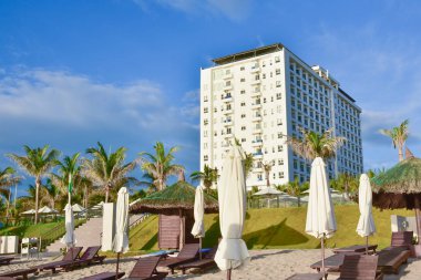 Otel bulutlu mavi gökyüzünün arka planda kumlu bir plaj ile ilk satırında. Kamran mı? Vietnam.