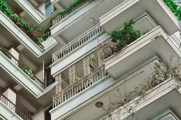 modern ecological building with lots of plants on the balcony