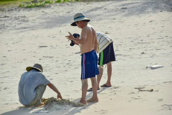 6 de julio de 2018. Vietnam. Cam Ranh. Los hombres cavan en la arena en la playa y atrapan cangrejos — Foto de Stock
