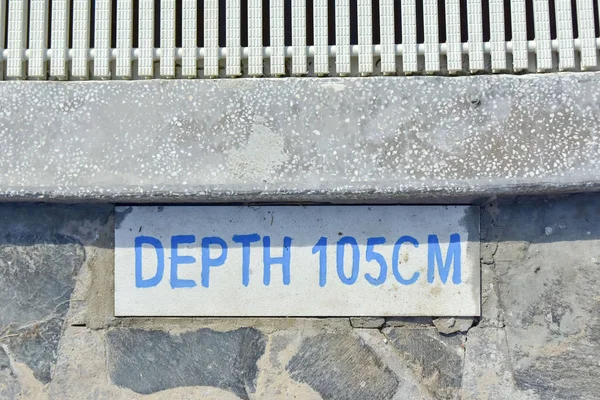 Placa de información con una inscripción en el lado de una piscina infantil DEPTH 105 CM. seguridad en el hotel — Foto de Stock