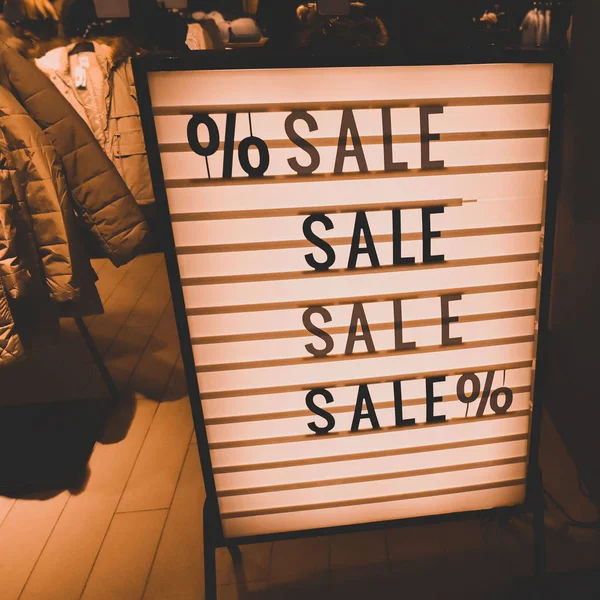 Stylish vintage sign. SALE in a showcase of a clothing store. Beautiful yellow lights — Stock Photo, Image