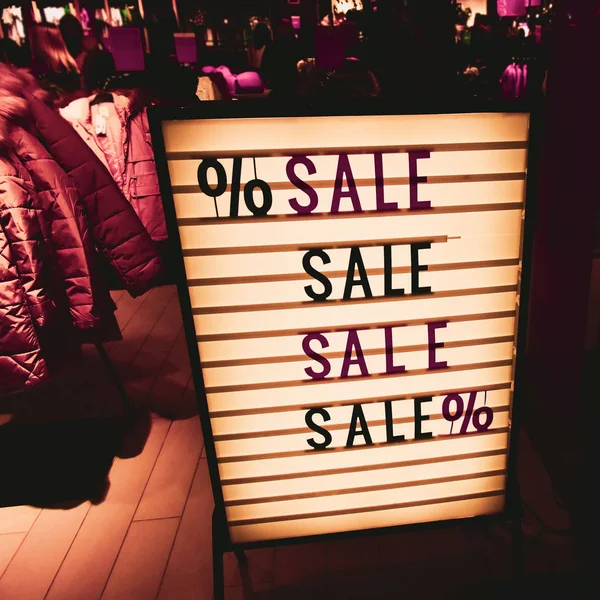 Stylish vintage sign. SALE in a showcase of a clothing store. Beautiful yellow lights — Stock Photo, Image