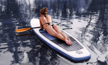 Mutlu paddleboard mavi su üzerinde duran göl kenarında yatılı kürek kurulu kadın kürek kadar stand sup.