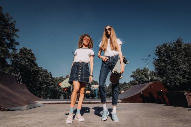 Kaykay rampa üzerinde çalışan mutlu arkadaşlar. İki kadın patenciler skate park adlı zevk.