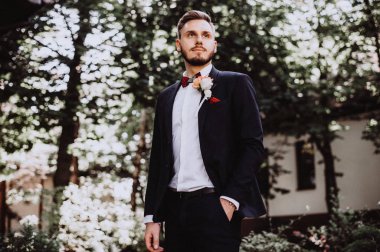 Düğün tuxedowaiting gelin, damat. Zengin düğün gününde damat. Zarif damat kostüm ve Papyon. İlik tutan takım elbiseli damat.