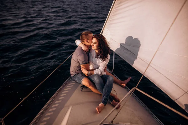 Genç bir çift rahatlatıcı bir yatta. Mutlu zengin bir adam ve bir kadın tarafından özel tekne deniz yolculuklar.