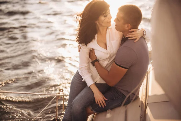 Romantik Çift yatta gün batımında sarılma