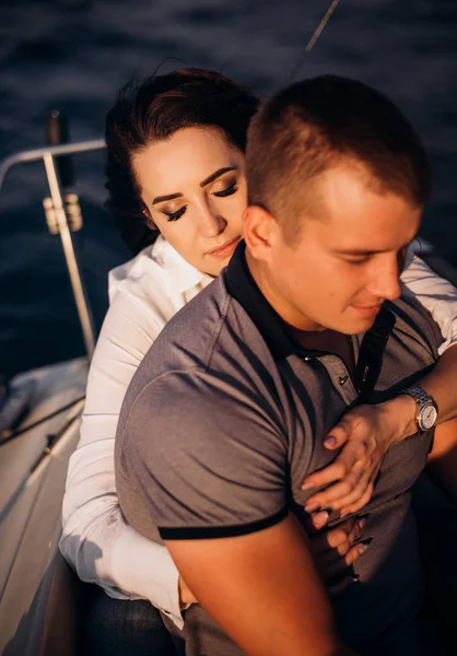 İki beyaz gençlerin günbatımı güneş ışığı altında yelken teknede yat - mutlu özel alternatif yaşam tarzı kavramı - aşk hikayesi aşık romantik çift.