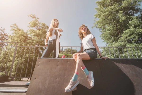 Duas Mulheres Patinadoras Amigos Sentados Rampa Hangout Parque Skate Rindo — Fotografia de Stock