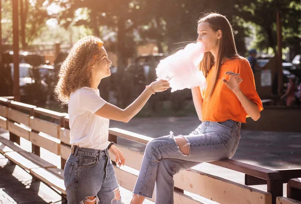 Eğleniyor ve pamuk şeker yemek mutlu genç kadın.