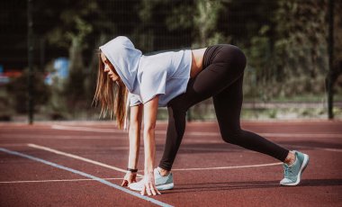 Gitmek için hazır! Kadın atlet başlangıç çizgisine Stadyumu parçanın üzerinde bir çalıştırmak için hazırlanıyor. Fitness kız düşük bir başlangıç çalıştırmak hazırlanıyor. Sağlıklı yaşam tarzı.