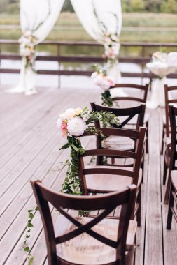 Giden düğün töreni. Dekor Studio. yeşil çim üzerinde kahverengi ahşap sandalyeler. Düğün bayram arch. Konuklar için beyaz koltuklar