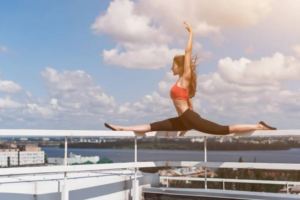 运动女孩做瑜伽和普拉提在摩天大楼的屋顶上 — 图库照片