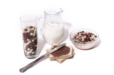 Sağlıklı kahvaltı. Süt, çikolatalı tatlı tahıllar bir kase ve fıstık hamur sürahi