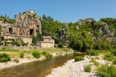 Kayalar mağara girişi ile görünümünü ve nehir Ardèche yakınındaki küçük ve çok güzel ortaçağ köyü Labeaume Fransa