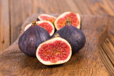 Grup tüm ve dilimlenmiş Olgun, lezzetli ve tatlılar incir eski rustik ahşap kesme tahtası