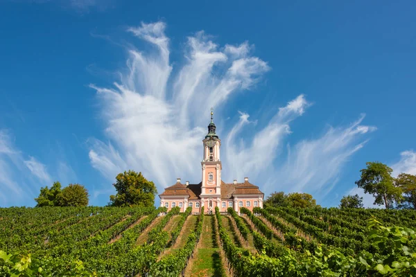 Vacker utsikt över pilgrimsfärdkyrkan i Birnau vid Bodensjön med vinrankorna i förgrunden med en spektakulär himmel och moln — Stockfoto